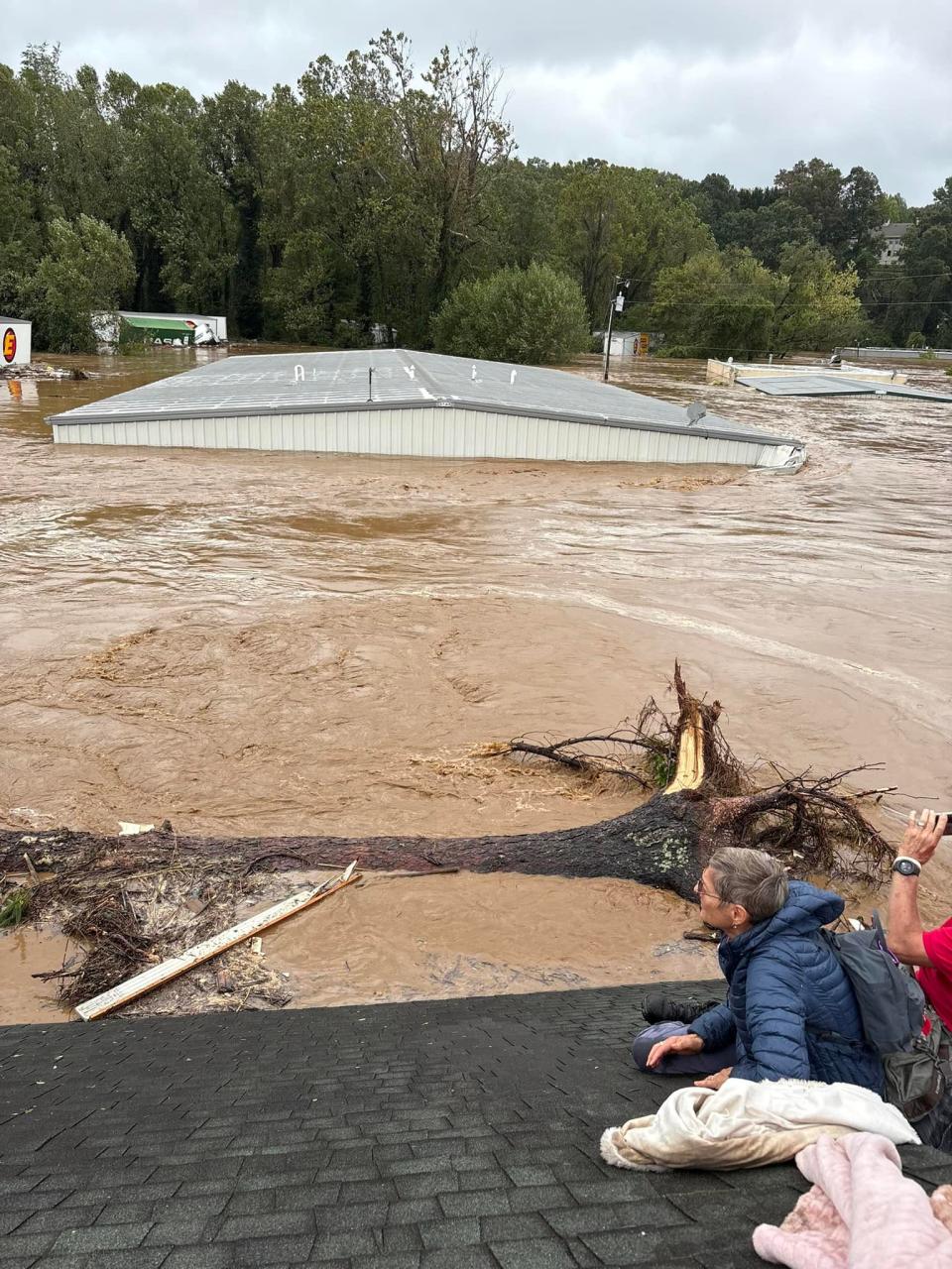 The Drye family on the roof of their home on Sept. 27, 2024. Megan Drye took this before the home collapsed in Helene's flooding.