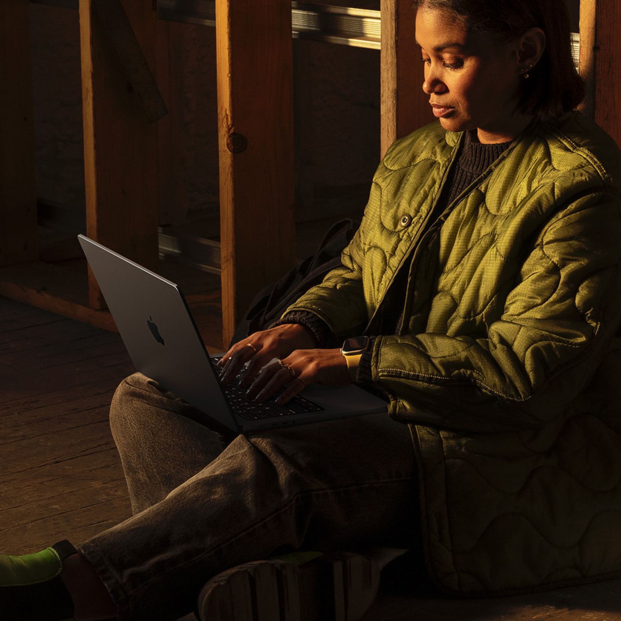 Someone sitting on ground using MacBook Pro