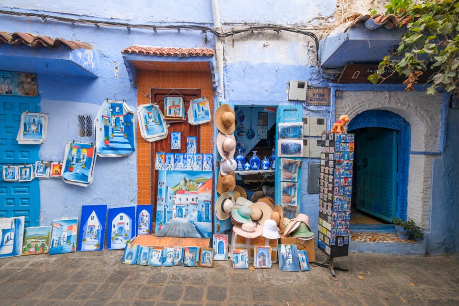 A souvenir shop sells hats and paintings.