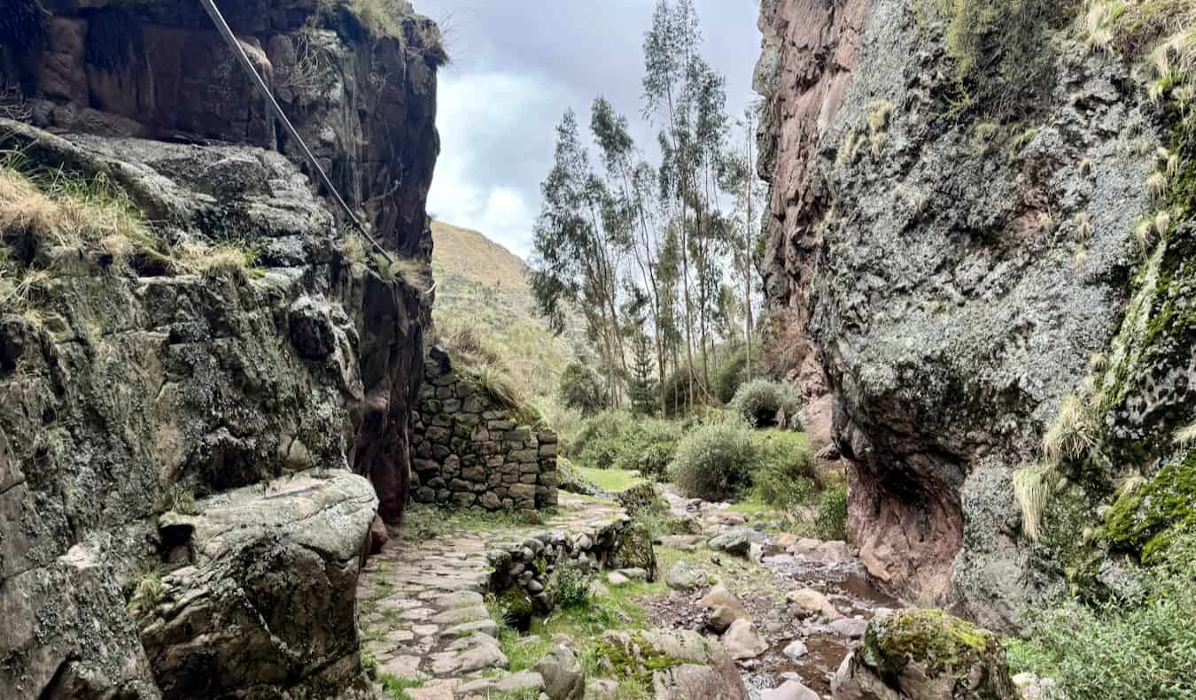 A narrow rock path with the ruins of Inca in Peru