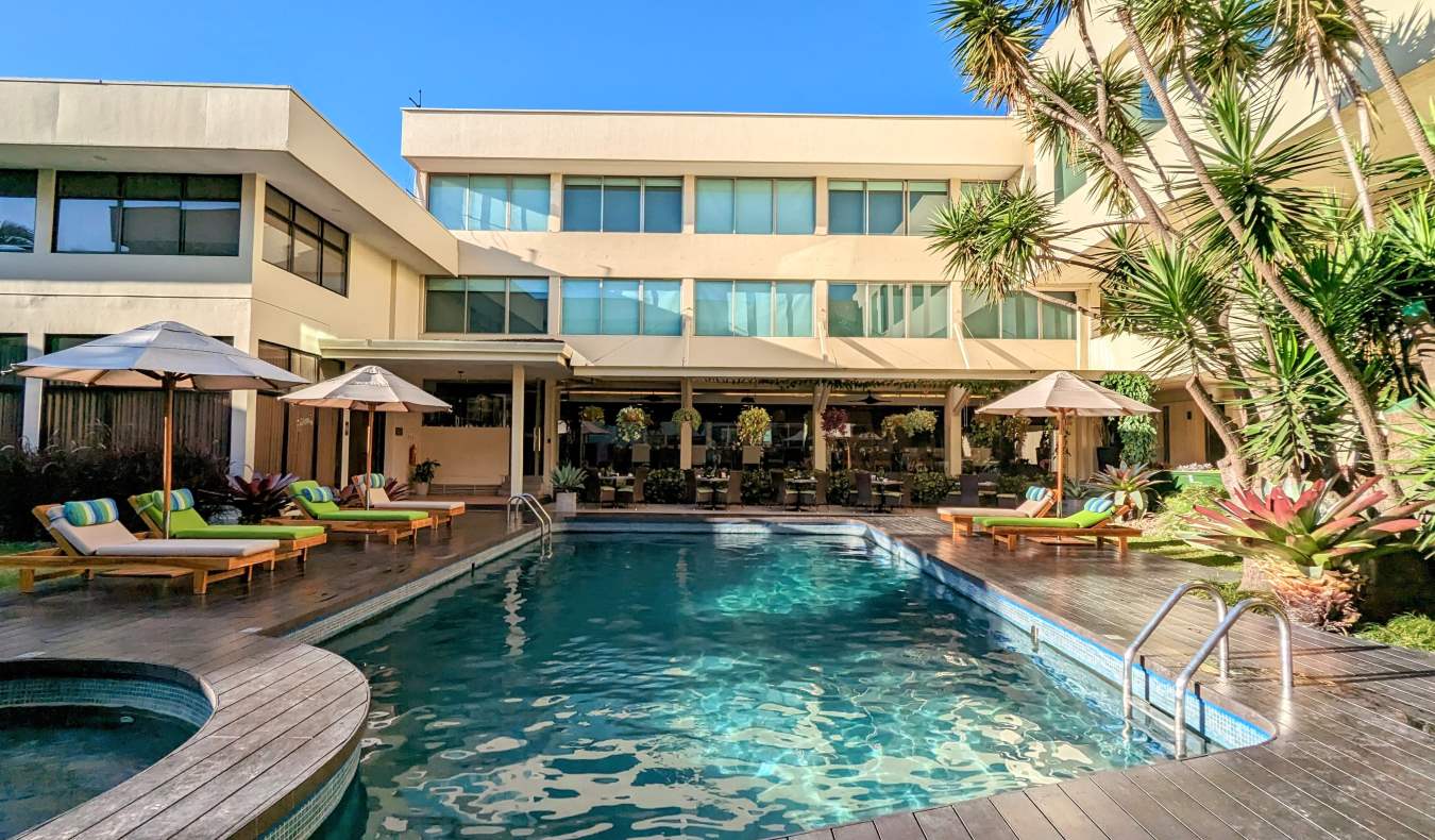 A swimming pool surrounded by chairs at a hotel in San Jose, Costa Rica