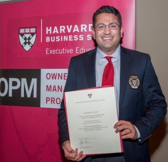 A man wears a suit with a certificate.