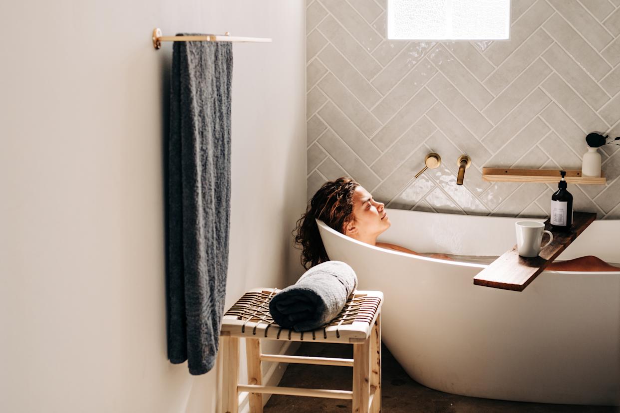 A woman relaxes in a bathtub.