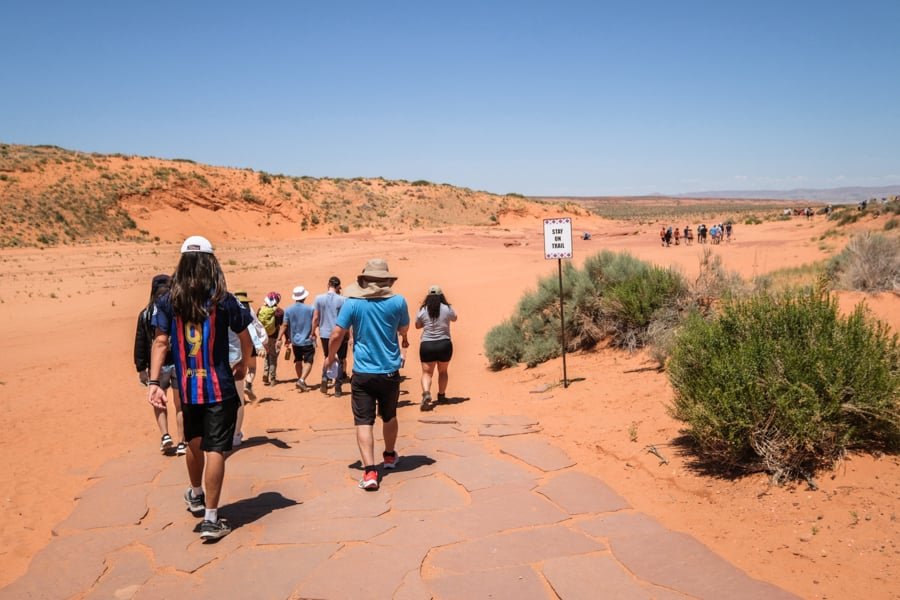 A group of tourists walking on a road in the desert