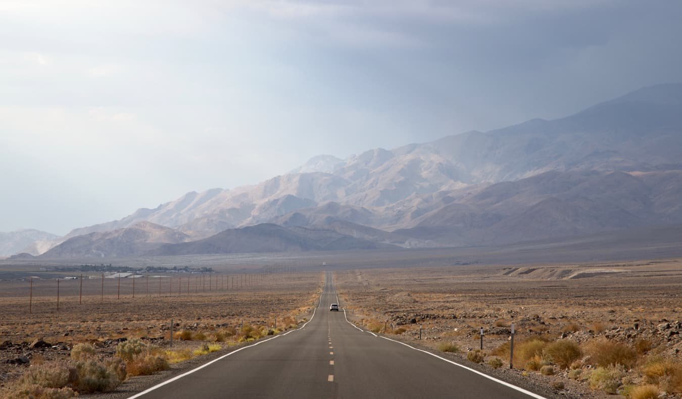 A car driving on an open road in Death Valley, USA