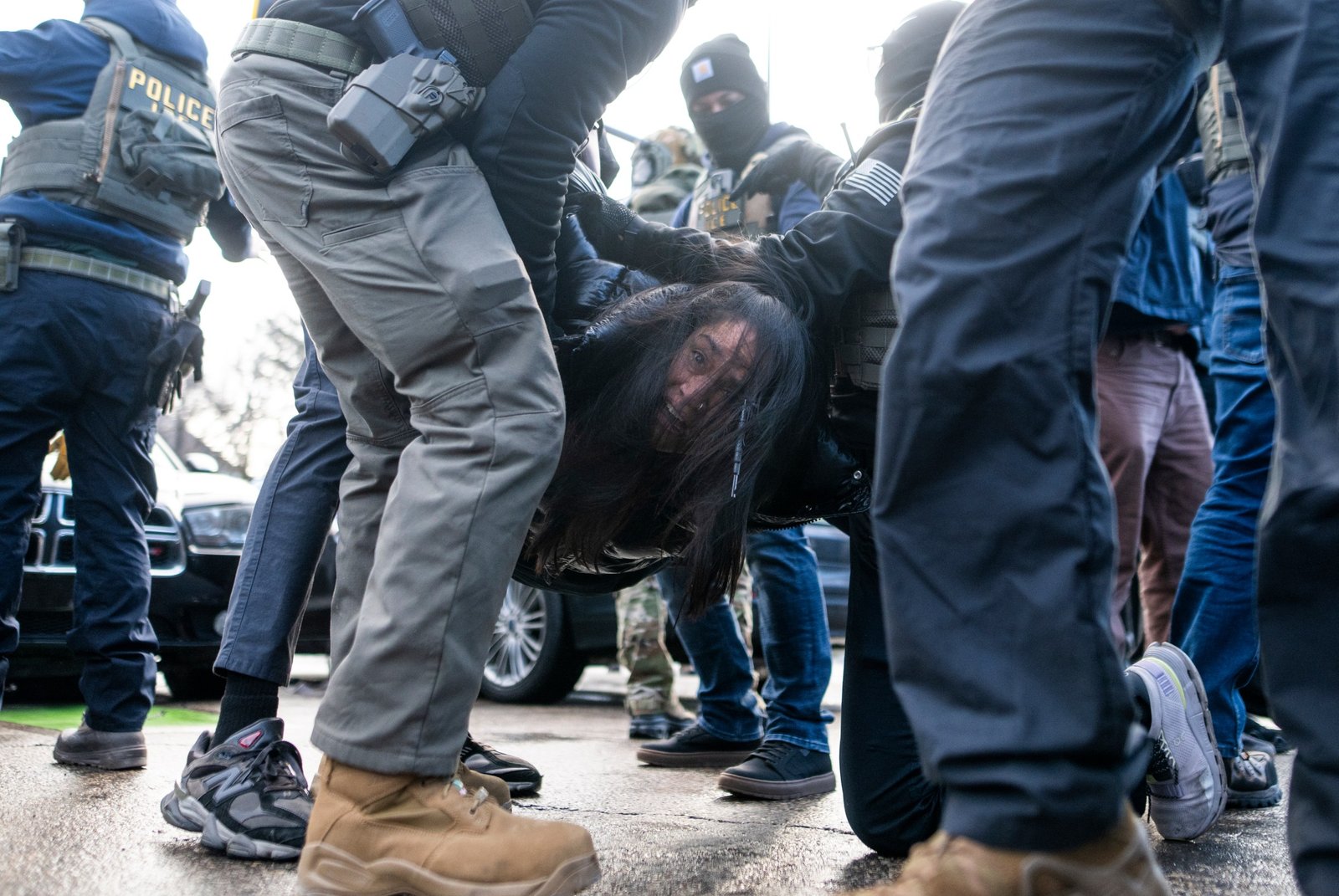 ICE agents detaining a woman