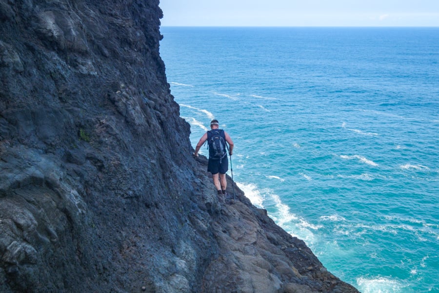 Hiker crossing the dangerous Crawlers Ledge cliff
