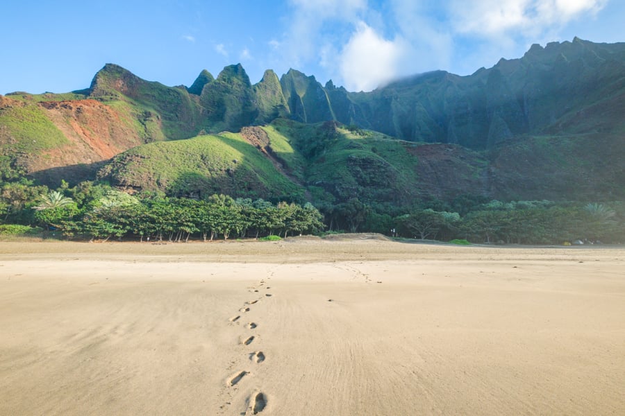 Footsteps in the sand below mountains at Kalalau Beach