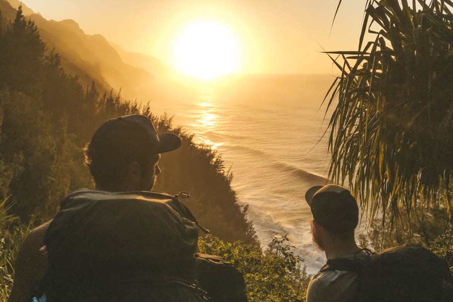 Two hikers in a sunset on the Na Pali coast