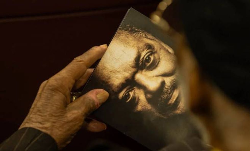 An attendee at the popular celebration of the Rev. Jesse Jackson holds a program bearing his image