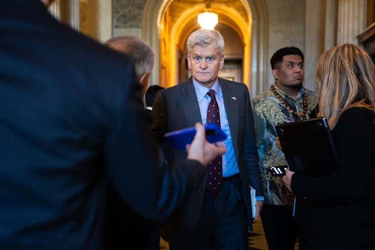 Sen. Bill Cassidy (R-La.) is surrounded by reporters in a U.S. Capitol hallway. 