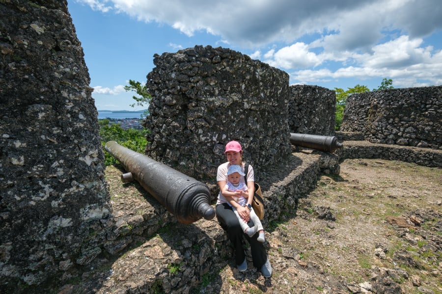 Sitting on the wall by a cannon at Benteng Keraton Buton Sultunate Fortress