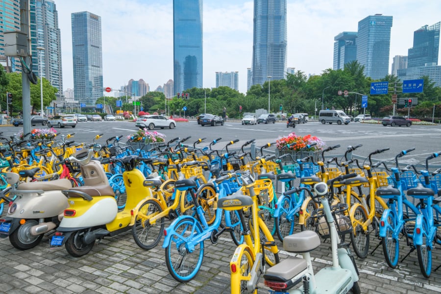 A row of yellow and blue bikes parked in the city