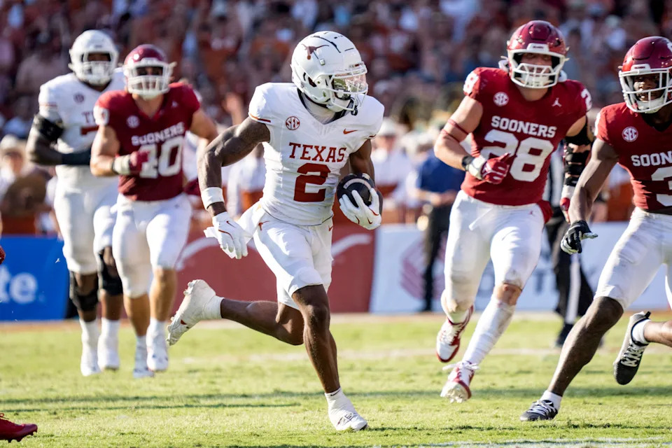 Texas Longhorns wide receiver Matthew Golden (2) runs upfield away from Oklahoma Sooners linebacker Danny Stutsman (28) and defensive lineman Ethan Downs (40) during an NCAA college football game against Oklahoma at the Cotton Bowl, Saturday, Oct. 13, 2024, in Dallas. Texas won 34-3. (AP Photo/Jeffrey McWhorter)
