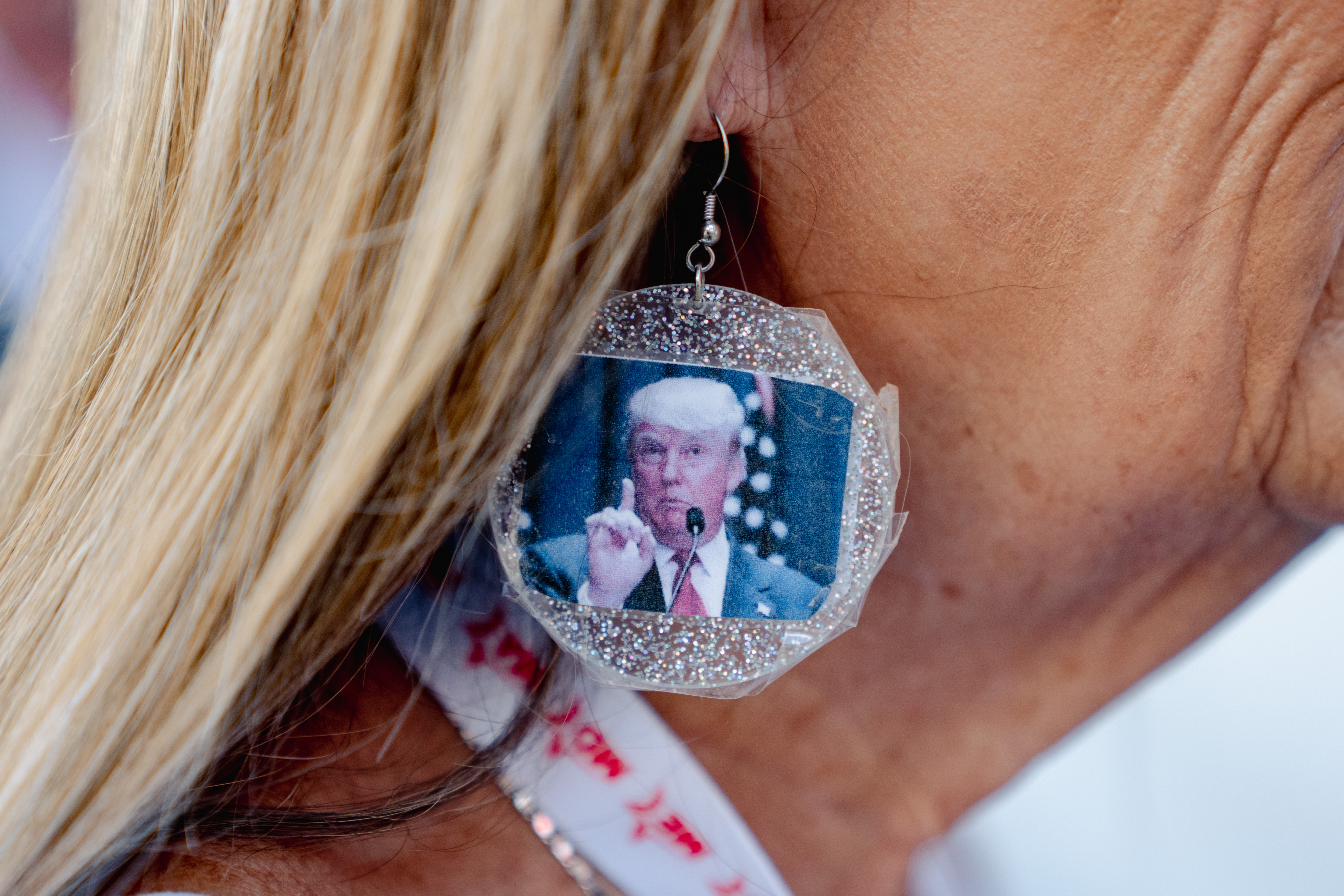 An attendee wears an earring featuring President Donald Trump—a visible sign of his enduring influence over the Republican Party.